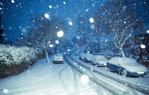 snowy street filled with cars