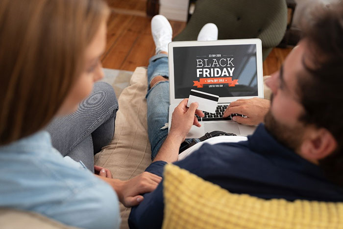 Man and woman doing Black Friday shopping on a laptop